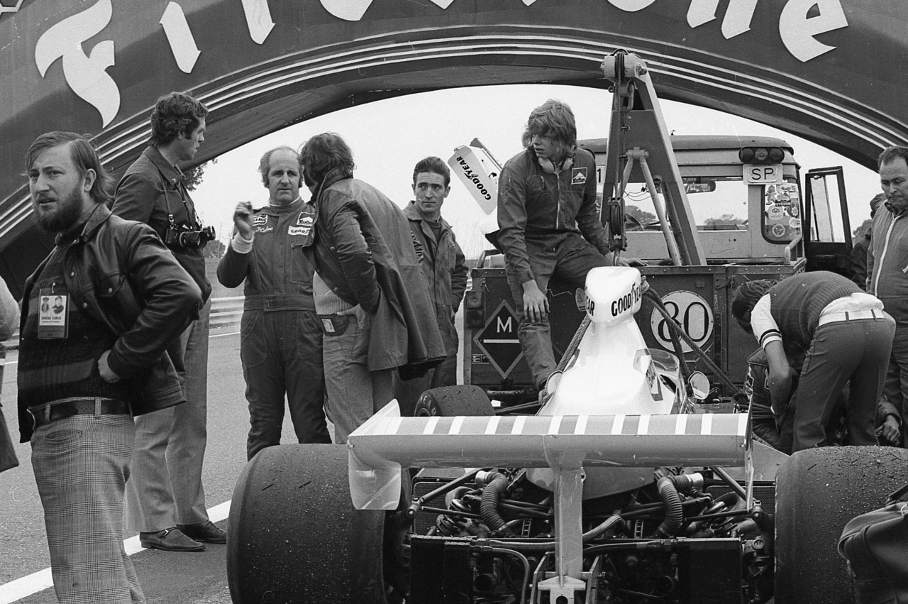 Denny Hulme explains to the team manager what happened.